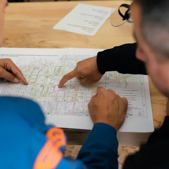 Dois profissionais analisando a planta de um processo
